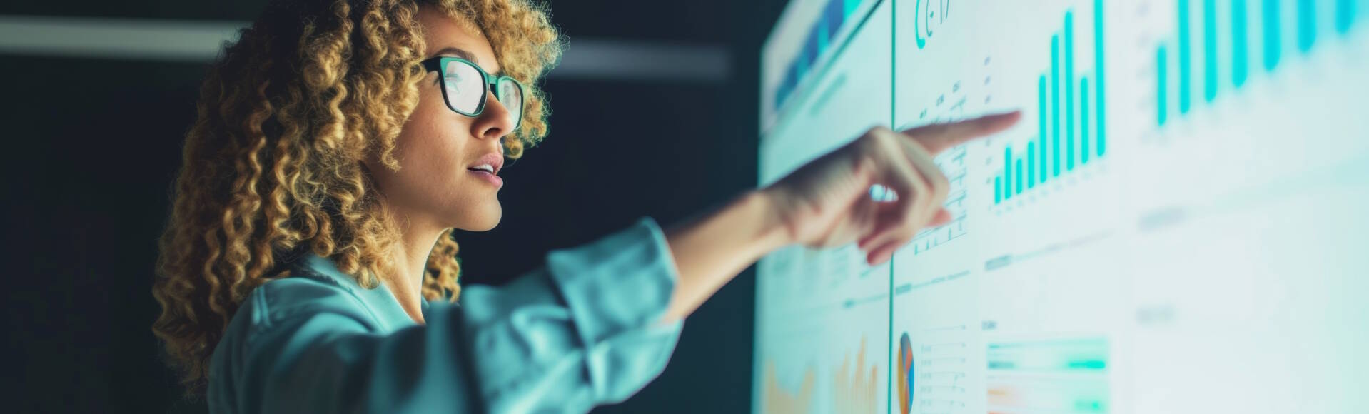 Analytical businesswoman presenting data on a large interactive display