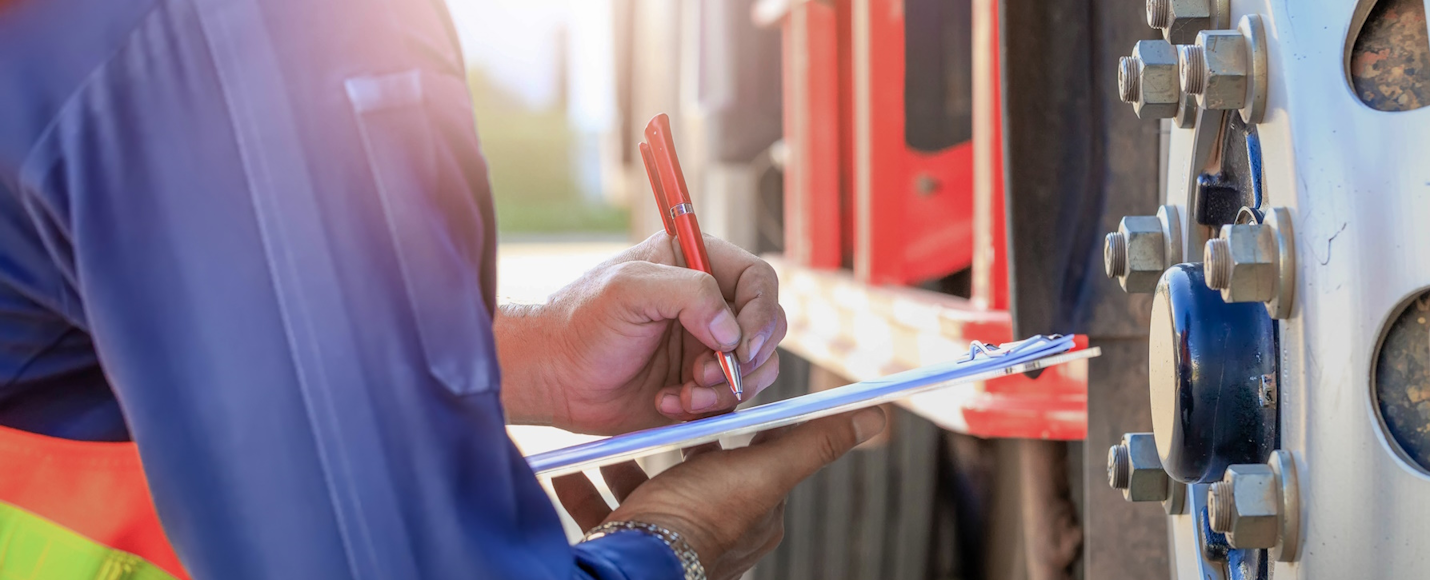 A person performing a safety inspection for a truck