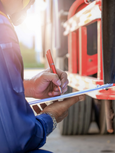 A person performing a safety inspection for a truck